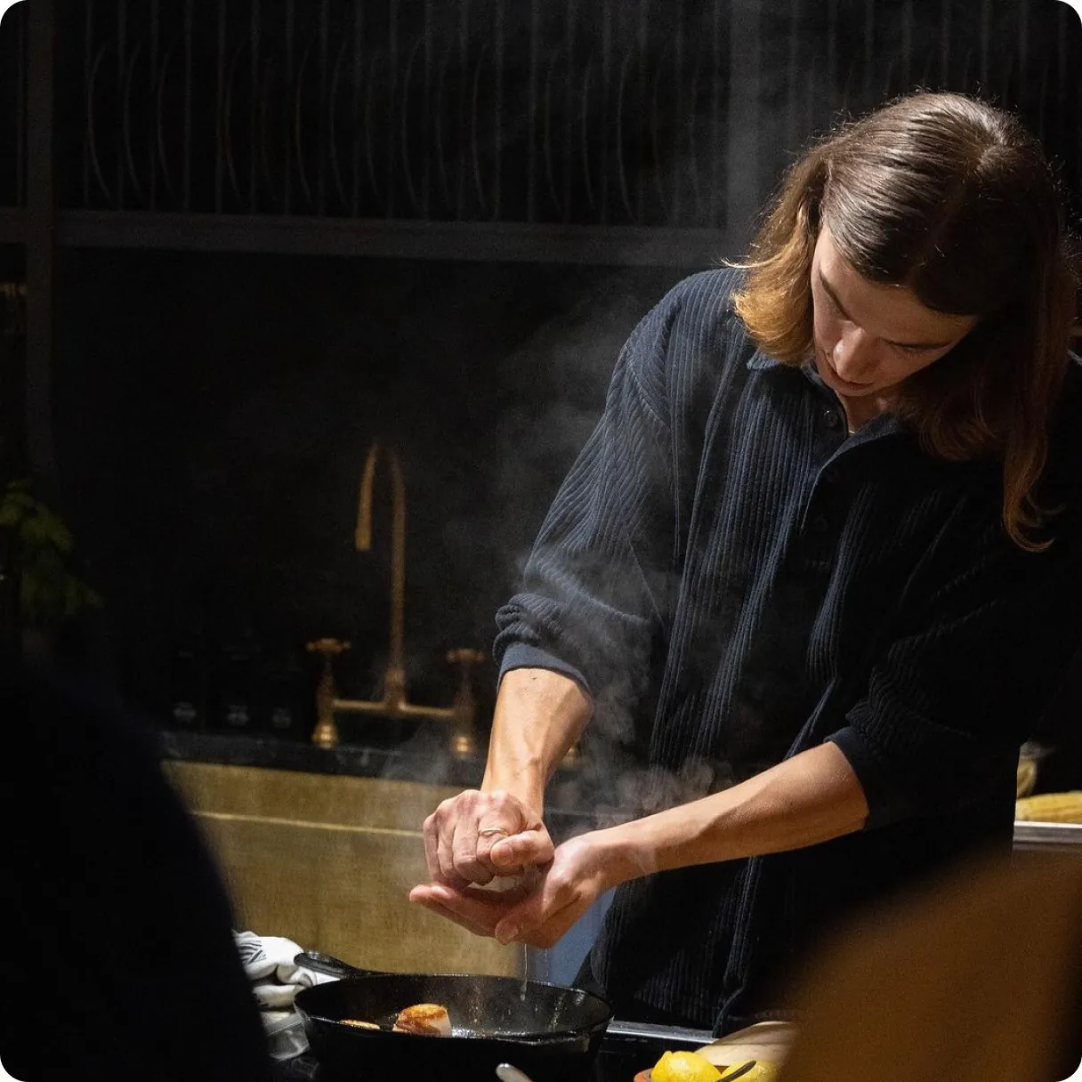 A private chef plating a dish in a home kitchen